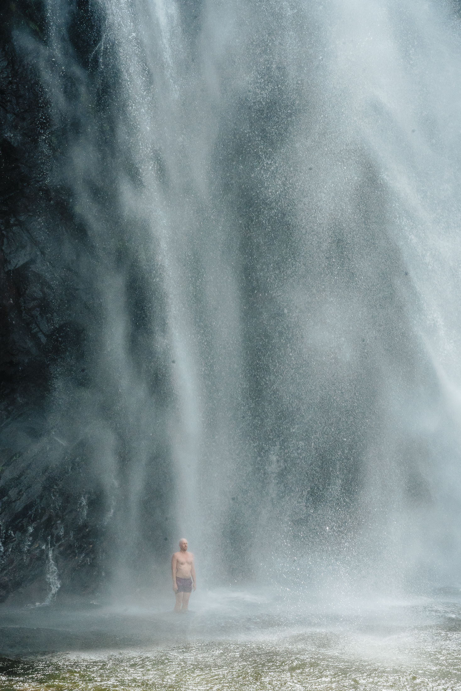 Persona bajo una cascada en el territorio de Jacaranda