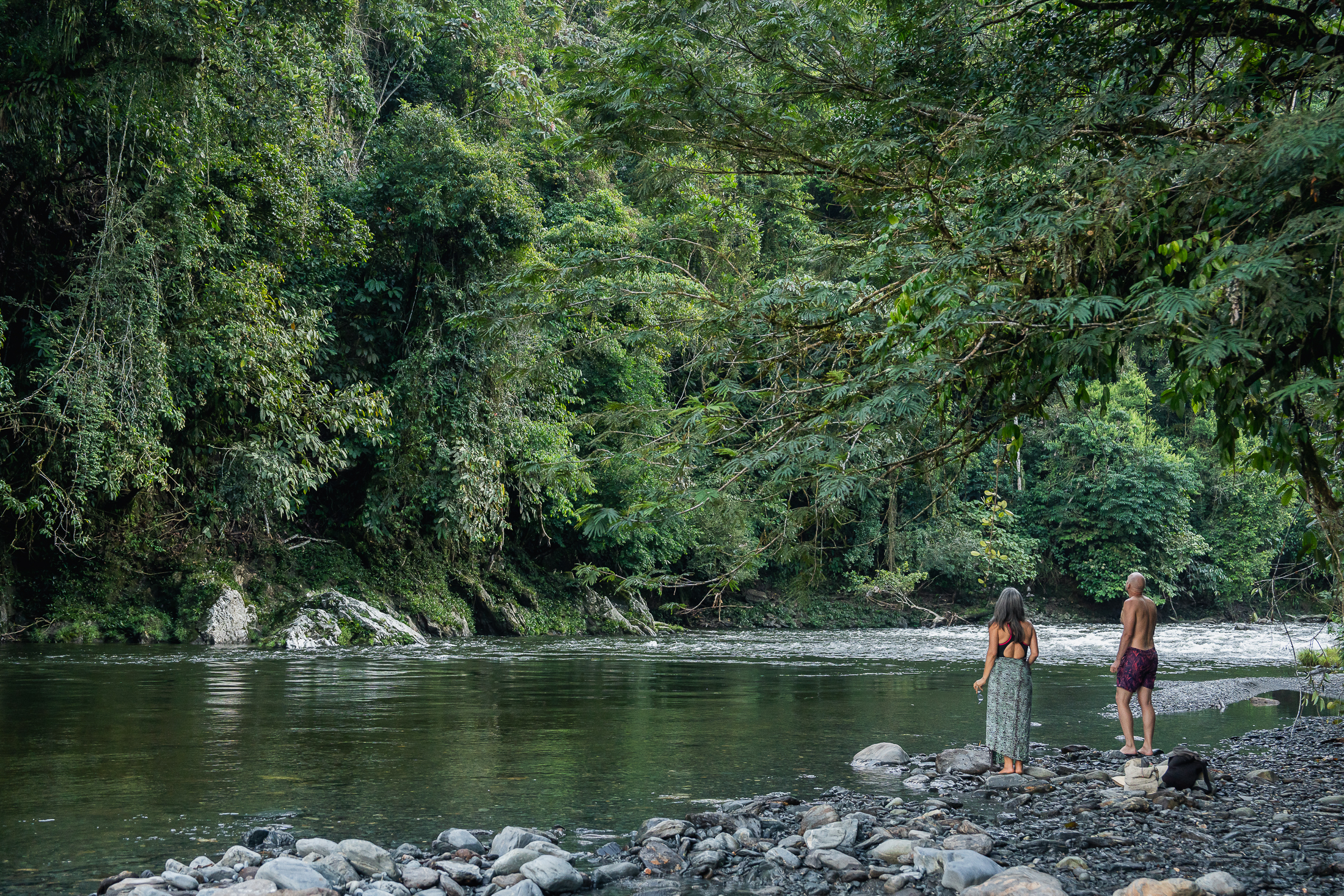 Visitantes en el río frente al camping
